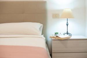 ein Schlafzimmer mit einem Bett und einer Lampe auf einem Nachttisch in der Unterkunft [Torregrande]APT.1-Con terrazzo a pochi metri dal mare - Free Wi-Fi in Torre Grande