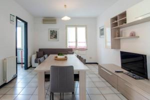 eine Küche und ein Wohnzimmer mit einem Tisch und einem Sofa in der Unterkunft [Torregrande]APT.1-Con terrazzo a pochi metri dal mare - Free Wi-Fi in Torre Grande