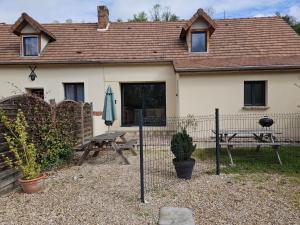 a house with a picnic table and an umbrella at L'Abaca 27 in Sainte-Geneviève-lès-Gasny