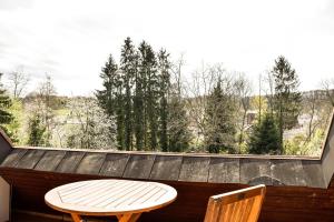 einen Tisch und zwei Stühle auf einem Balkon mit einem großen Fenster in der Unterkunft am Hohlebach in Schliengen