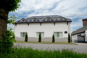 a white house with a black roof at Casa Bolta Rece in Sighetu Marmaţiei