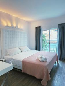 Un dormitorio con una cama grande y una ventana en bhc Boutique Hostal Cala Millor, en Cala Millor