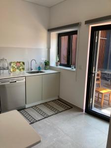 uma cozinha com um lavatório e uma porta para um pátio em CASA ANJOS em Amarante