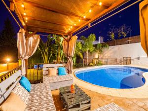 una piscina al aire libre con muebles de exterior y una piscina al aire libre en Cubo's Villa Esmeralda, en Alhaurín el Grande