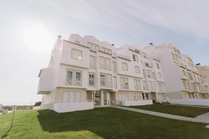 a large white building with a grass yard at Best Houses 84 - Mar Salgado in Ferrel