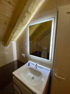 a bathroom with a sink and a mirror at Adenisi guesthouse in Tropojë