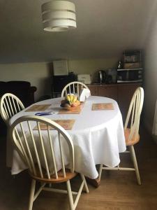 a dining room table with a white tablecloth and two chairs at Meadow House in County Donegal in Donegal