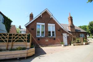 a brick house with a wooden fence in front of it at The Old Schoolhouse in Whitstable