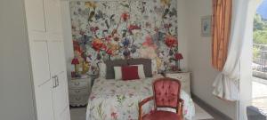 ein Schlafzimmer mit einem Bett und einem roten Stuhl in der Unterkunft Chambres d'hôtes Les Iris in Sospel
