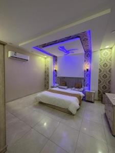 ein Schlafzimmer mit einem großen Bett mit violetter Beleuchtung in der Unterkunft شاليهات الفخامة in Ḑubā