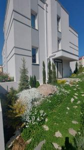 a white building with a yard with flowers in front of it at SAPPHIRE in Sozopol