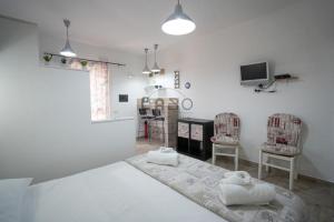 Zimmer mit einem Bett, 2 Stühlen und einem TV in der Unterkunft Ilios in Tropea