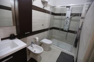 a bathroom with a shower and a toilet and a sink at La casa di Anna in Fluminimaggiore +12 photos