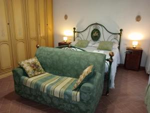 um quarto com um sofá verde e uma cama em B&B A Casa Mia em Pisa