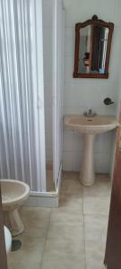 a bathroom with a sink and a mirror at Apartamento Rosa in Porto Covo
