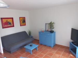 sala de estar con sofá y TV en Mazet Provençal dans Village Vacances, en Gaujac