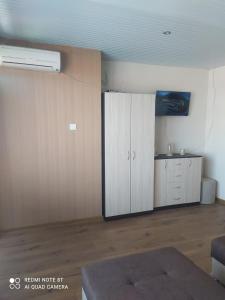ein Wohnzimmer mit einem weißen Schrank und einem Zimmer in der Unterkunft Exotic Guest House in Sozopol