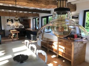a kitchen with a large glass bottle hanging from the ceiling at ROUGE COTTAGE Gîte 4 étoiles Billard in Gueutteville-les-Grès
