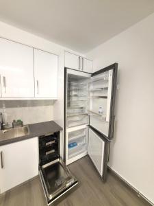 un frigorifero con porta aperta in cucina di Dual Delights- Romantic Jacuzzi Suite and Spacious Family Apartment-Metro station 180m ad Atene