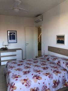 een slaapkamer met een groot bed met een sprei met bloemen bij La Cirica in Marzamemi