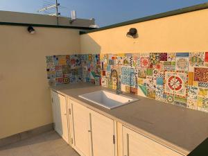 cocina con fregadero y pared de azulejos en La Cirica, en Marzamemi