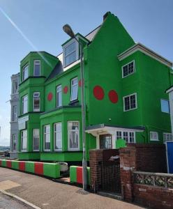 a green building with red and green circles on it at Ash Hotel B&B in Exmouth