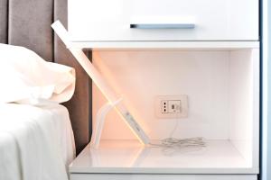 a white nightstand with a light switch and a clock at ALBA in Tirana