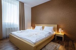 una camera da letto con un grande letto con lenzuola bianche di TATRYSTAY Oliver Apartments a Štrbské Pleso