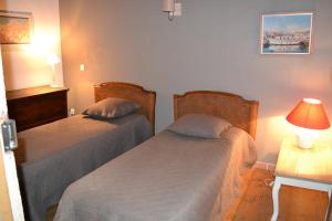1 dormitorio con 2 camas y mesa con lámpara en a Casa, en Calenzana