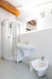 uma casa de banho branca com um lavatório e um chuveiro em Monolocale adiacente al centro con posto auto em Schio