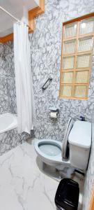 baño con aseo y pared de piedra en Solar paneled home. Worry free for outages., en Bacolod