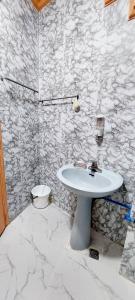 La salle de bains est pourvue d'un lavabo blanc et d'un mur en pierre. dans l'établissement Solar paneled home. Worry free for outages., à Bacolod
