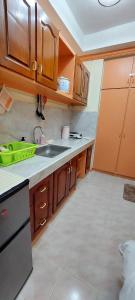 a kitchen with wooden cabinets and a sink at Solar paneled home. Worry free for outages. in Bacolod