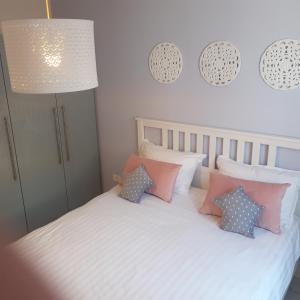 ein Schlafzimmer mit einem Bett mit Kissen und einer Lampe in der Unterkunft Villa Dolce Amaro in Izola