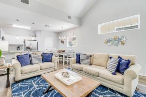 a living room with two couches and a table at Carpe BeachBum in Port Aransas