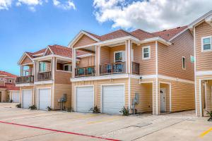 a large house with two garages in a parking lot at Carpe BeachBum in Port Aransas