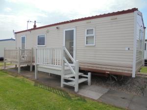 a tiny house with two chairs and a porch at 6 Berth Sealands Ingoldmells Central heated (Carlton) in Ingoldmells