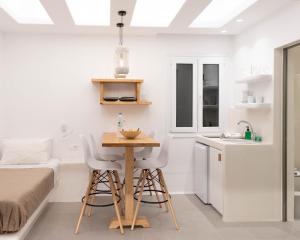 a small white kitchen with a table and chairs at Dedalos Studios Naxos in Naxos Chora