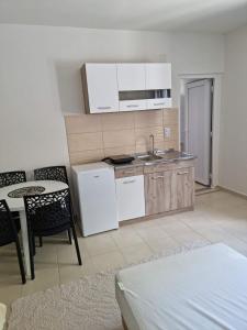 a kitchen with white appliances and a table and chairs at HM Apartmani in Bar +53 photos