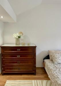 a bedroom with a dresser with a vase of flowers on it at Istrian house Casa del nonno in Šmarje