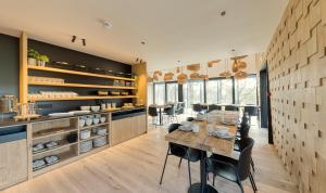 a kitchen with a table and chairs in a room at Wood (Forestia) in Theux