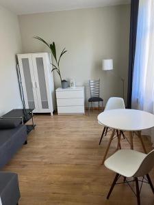 a living room with a white table and chairs at Apartamenty Oliwa in Gdańsk