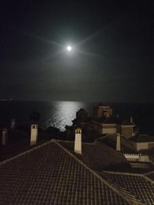 a view of the moon over the ocean at night at ADNANIa 2023 in La Herradura