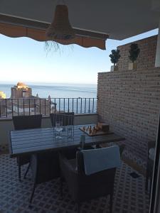 a patio with a table and chairs and a view of the ocean at ADNANIa 2023 in La Herradura