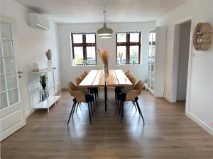 a dining room with a wooden table and chairs at Hyggeligt sommerhus i Jerup in Jerup