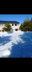 un patio cubierto de nieve con un edificio y árboles en Casa Catedral Bariloche en San Carlos de Bariloche