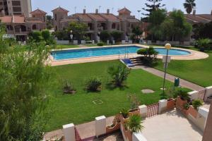 une image d'une piscine dans une cour dans l'établissement Duplex junto al Mar con Jardin y Piscina, à Puerto de Mazarrón 30 autres photos
