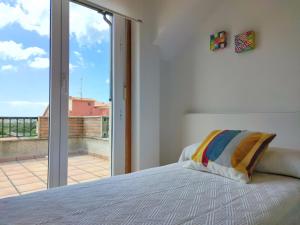 a bedroom with a bed and a large window at Desconectaengalicia Ático La Lanzada in A Lanzada