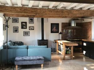 a living room with a blue couch and a table at ROUGE COTTAGE Gîte 4 étoiles Billard in Gueutteville-les-Grès