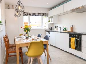 a kitchen with a dining room table and chairs at Seaside House in Great Yarmouth